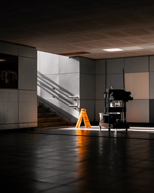 A modern, clean interior of an office or public space near Uxbridge Station, featuring smooth wooden flooring and tall, cylindrical black columns arranged in parallel lines. The ceiling has a curved, 